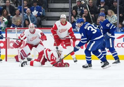 Apr 17, 2025; Toronto, Ontario, CAN; Toronto Maple Leafs center Auston Matthews (34) battles for the puck with Detroit Red Wings center Tyler Motte (14) during the second period at Scotiabank Arena.