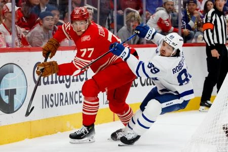 Oct 11, 2025; Detroit, Michigan, USA; Detroit Red Wings defenseman Simon Edvinsson (77) and Toronto Maple Leafs left wing Nicholas Robertson (89) battle for the puck in the first period at Little Caesars Arena. Mandatory Credit: Rick Osentoski-Imagn Images