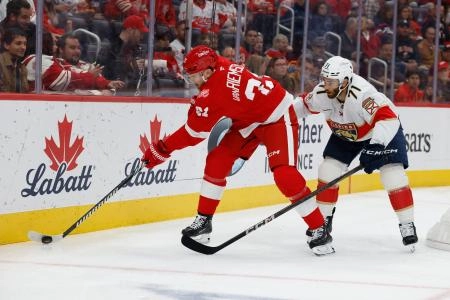 Oct 15, 2025; Detroit, Michigan, USA; Detroit Red Wings left wing James van Riemsdyk (21) skates with the puck chased by Florida Panthers center Luke Kunin (71) in the second period at Little Caesars Arena. Mandatory Credit: Rick Osentoski-Imagn Images