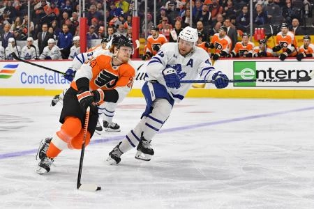 Philadelphia Flyers forward Owen Tippet attempting to get past Toronto Maple Leafs defenseman Morgan Rielly.