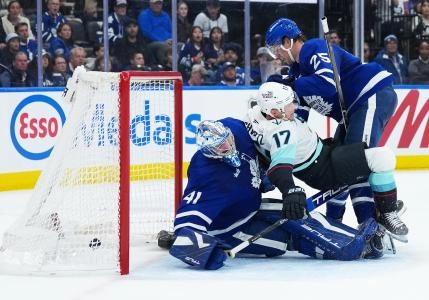 Oct 18, 2025; Toronto, Ontario, CAN; Toronto Maple Leafs defenseman Brandon Carlo (25) battles with Seattle Kraken left wing Jaden Schwartz (17) as the puck goes past goaltender Anthony Stolarz (41) for a goal during the second period at Scotiabank Arena. Mandatory Credit: Nick Turchiaro-Imagn Images
