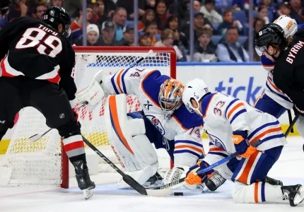 Buffalo's Alex Tuch reaches for puck in Oilers' crease during an Edmonton road game