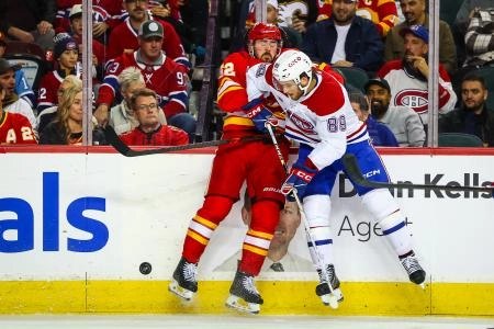 Oct 22, 2025; Calgary, Alberta, CAN; Montreal Canadiens right wing Joshua Roy (89) and Calgary Flames defenseman Mackenzie Weegar (52) battles for the puck during the second period at Scotiabank Saddledome. Mandatory Credit: Sergei Belski-Imagn Images