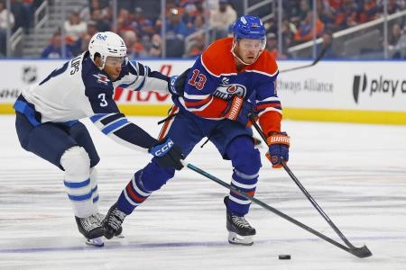 Sep 26, 2025; Edmonton, Alberta, CAN; Winnipeg Jets defensemen Isaak Phillips (3) tries to knock the puck away from Edmonton Oilers forward Mattias Janmark (13) during the first period at Rogers Place. Mandatory Credit: Perry Nelson-Imagn Images