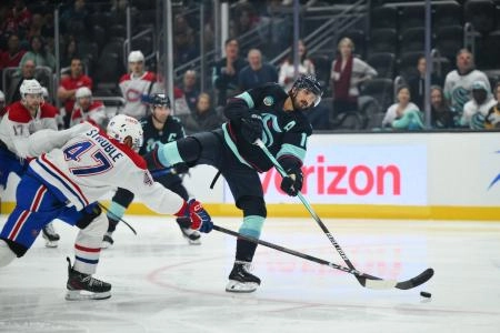 Oct 28, 2025; Seattle, Washington, USA; Seattle Kraken center Matty Beniers (10) shoots the puck while defended by Montreal Canadiens defenseman Jayden Struble (47) during the third period at Climate Pledge Arena. Mandatory Credit: Steven Bisig-Imagn Images