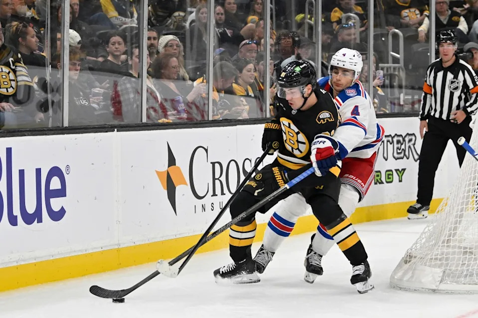 Rangers defenseman Braden Schneider (4) lifts the stick of Boston Bruins center Michael Eyssimont (81) during the third period at TD Garden. Eric Canha-Imagn Images