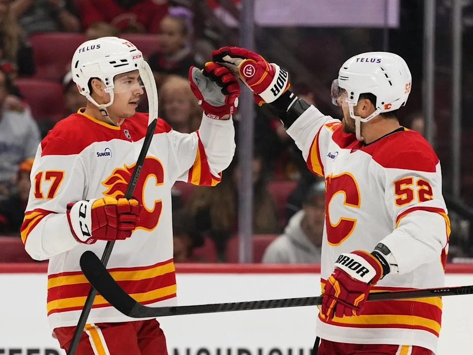  Flames forward Yegor Sharangovich, left, celebrates his goal on Thursday with Mackenzie Weegar.