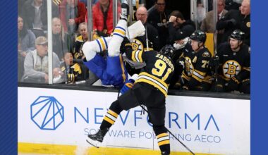 Boston Bruins' Nikita Zadorov (91) checks Buffalo Sabres' Owen Power, center left, during the first period of an NHL hockey game, Saturday, Oct. 11, 2025, in Boston. (AP Photo/Michael Dwyer)