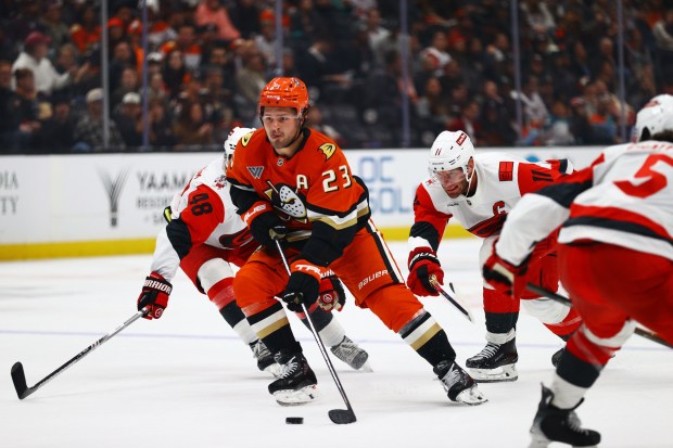 Ducks center Mason McTavish (23) fights for control of the...