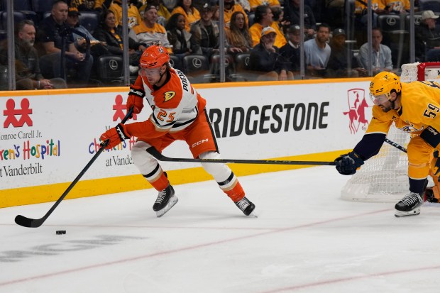Ducks center Ryan Poehling, left, chases the puck past Nashville...