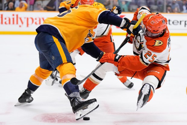 Ducks center Ryan Poehling (25) is knocked off is skates...