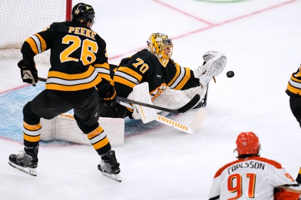 Boston Bruins goaltender Joonas Korpisalo (70) reaches for the puck...