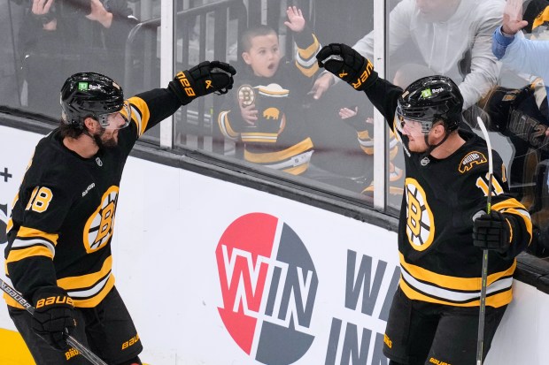 Boston Bruins center Casey Mittelstadt, right, celebrates after his first...