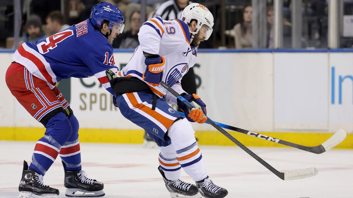 Edmonton Oilers center Adam Henrique (19) fights for the puck against New York Rangers right wing Taylor Raddysh (14) during the second period at Madison Square Garden.