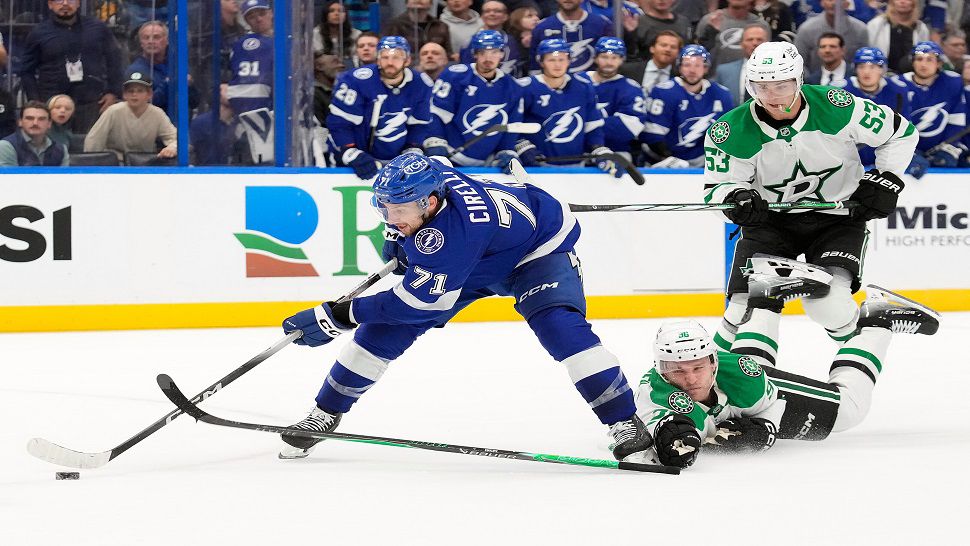 Tampa Bay Lightning center Anthony Cirelli (71) gets past Dallas Stars right wing Mikko Rantanen (96) and center Wyatt Johnston (53) on the way to scoring the game-winning goal during overtime an NHL hockey game Thursday, Oct. 30, 2025, in Tampa, Fla. (AP Photo/Chris O'Meara)