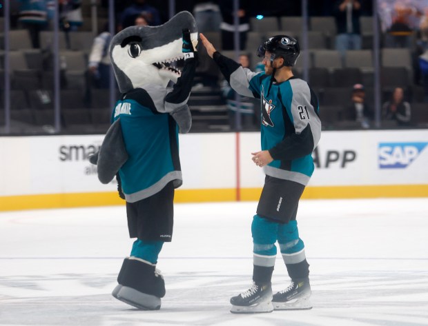 San Jose Sharks' Alexander Wennberg (21) high-fives SJ Sharkie after...