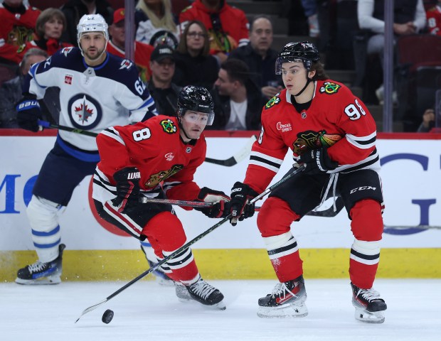 The Blackhawks' Ryan Donato (8) and Connor Bedard look to make a play against the Jets on April 12, 2025, at the United Center. (Chris Sweda/Chicago Tribune)