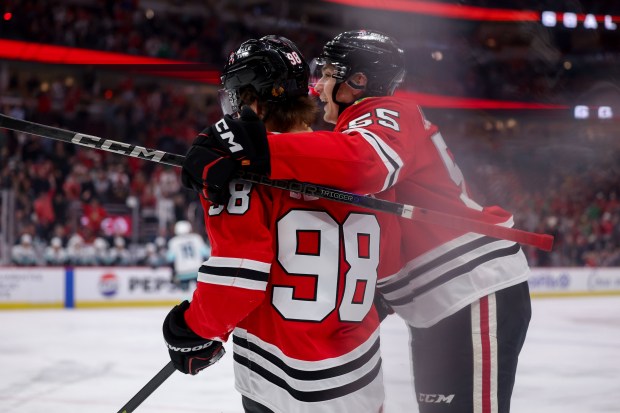 Chicago Blackhawks defenseman Artyom Levshunov (55) celebrates with Chicago Blackhawks center Connor Bedard (98) after he scored a goal during the first period against the Seattle Kraken at the United Center Tuesday March 18, 2025, in Chicago. (Armando L. Sanchez/Chicago Tribune)