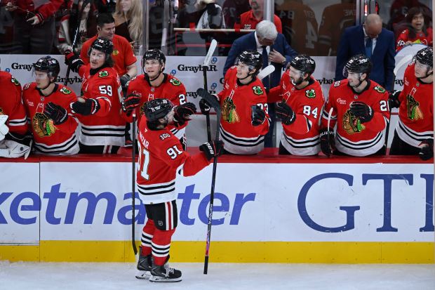Chicago Blackhawks' Frank Nazar (91) celebrates with teammates at the bench after scoring during the third period of an NHL hockey game against the Anaheim Ducks, Sunday, Oct. 19, 2025, in Chicago. (AP Photo/Paul Beaty)