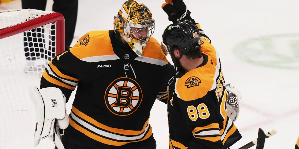 Jeremy Swayman and David Pastrnak celebrating a win