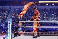 Montez Ford leaps onto Chad Gable and teammate Angelo Dawkins (bottom) during a match at...