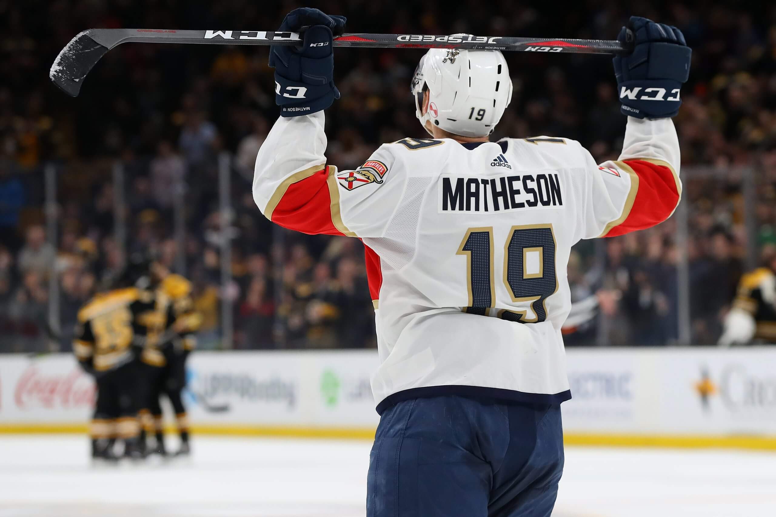 Mike Matheson, seen from the back, rests his stick on his helmet in defeat.