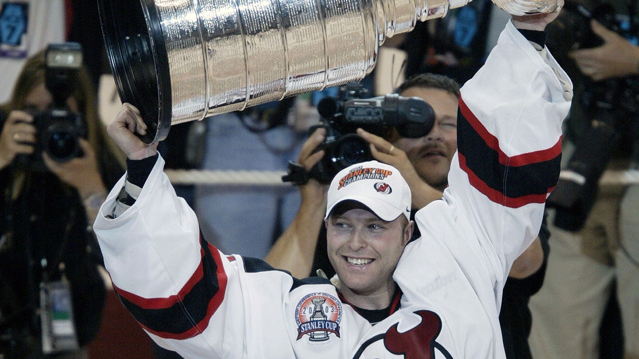 Martin Brodeur #30 holds up the Stanley Cup trophy after defeating the Mighty Ducks of Anaheim 3-0 in Game 7 of the 2003 Stanley Cup Final. (Al Bello/Getty Images/NHLI)