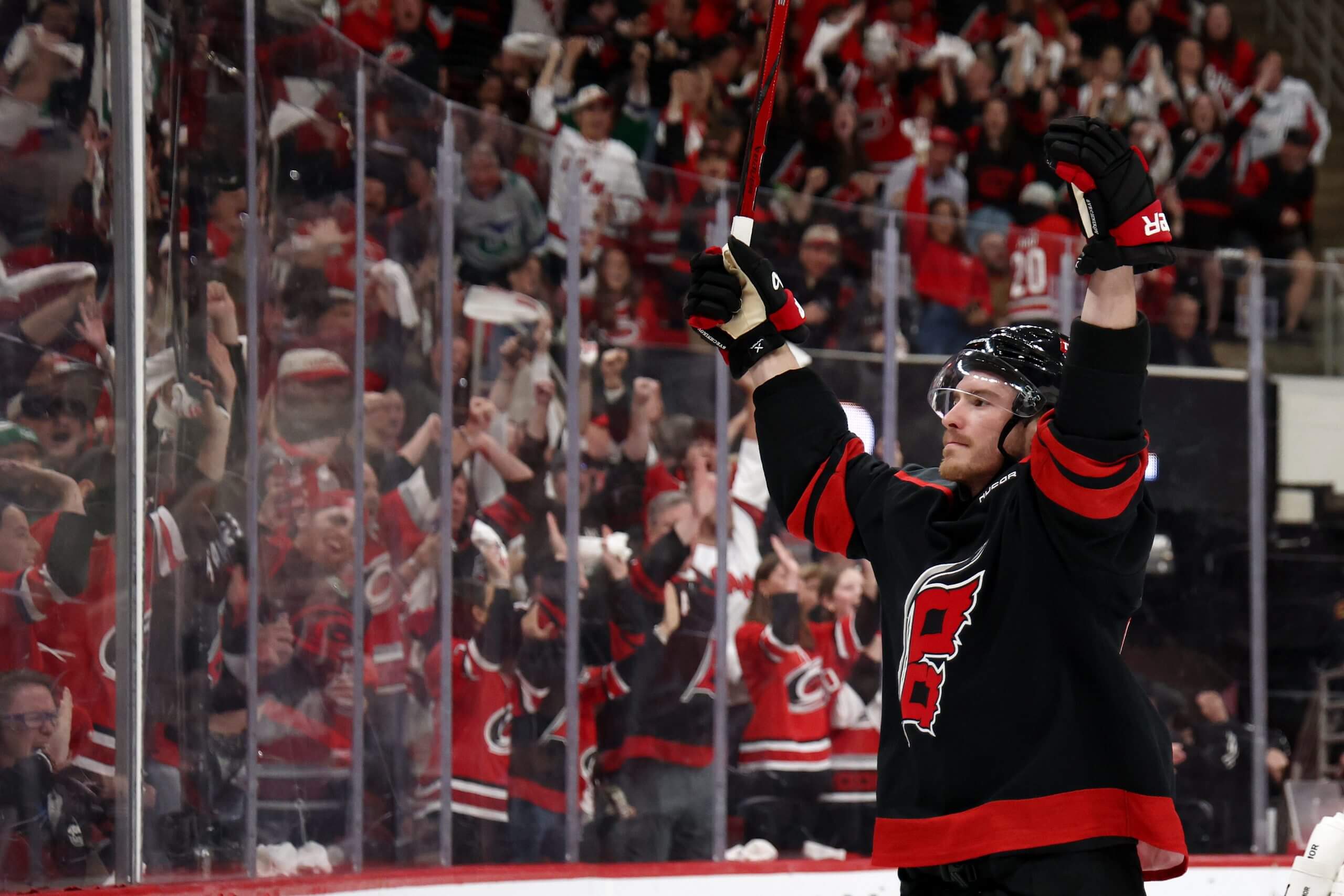 Andrei Svechnikov raises both arms to a roaring Hurricanes crowd after scoring a goal.