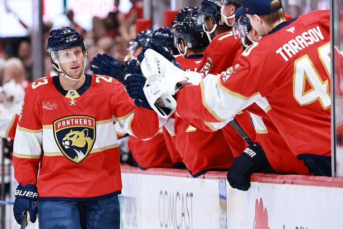 Carter Verhaeghe #23 of the Florida Panthers high fives teammates after scoring against the Chicago Blackhawks during the first period at Amerant Bank Arena on October 07, 2025 in Sunrise, Florida.