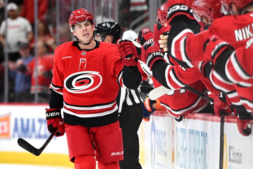 Carolina Hurricanes defenseman Mike Reilly (6) fist bumps teammates after scoring during the NHL game between the New York Islanders and the Carolina Hurricanes on October 30, 2025 at Lenovo Center in Raleigh, North Carolina. 