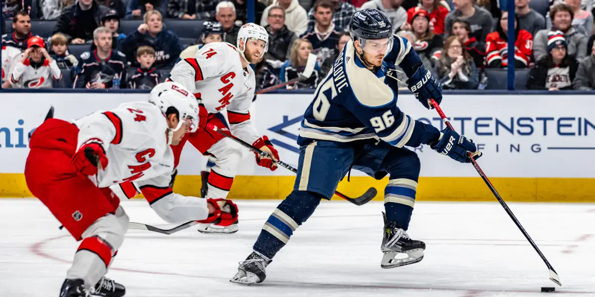 Jack Roslovic with the puck trying to get through Carolina's defense