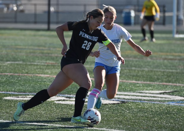 Pennridge's Emma Shaeffer, 28, with the ball as North Penn's Alyssa Chartrand, 11, defends during their game on Thursday, Oct. 16, 2025 at Helman Field. (Mike Cabrey/MediaNews Group)