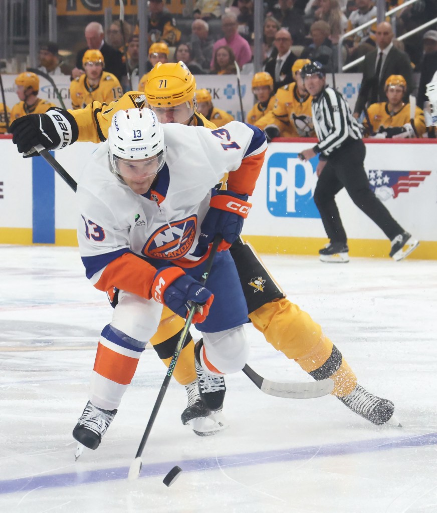 New York Islanders center Mathew Barzal (13) moves the puck ahead of Pittsburgh Penguins center Evgeni Malkin (71) during the first period at PPG Paints Arena. 