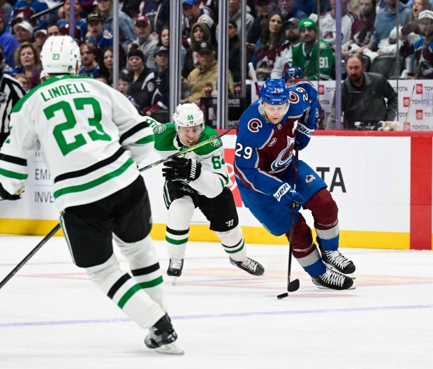 Colorado Avalanche center Nathan MacKinnon (29) takes the puck down ice against Dallas Stars center Mikael Granlund (64) and Esa Lindell (23) in the first period of game four of the first round of the NHL playoffs at Ball Arena in Denver on Saturday, April 26, 2025. (Photo by Andy Cross/The Denver Post)