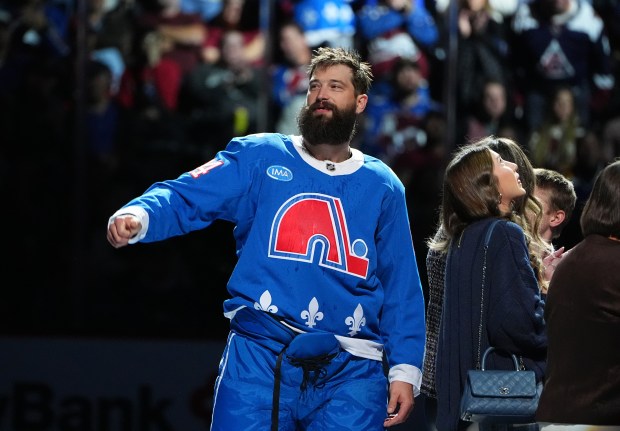 Colorado Avalanche defenseman Brent Burns gestures as he is honored for playing his 1,500th game before the first period of an NHL hockey game against one of his former teams, the Carolina Hurricanes, Thursday, Oct. 23, 2025, in Denver. (AP Photo/David Zalubowski)