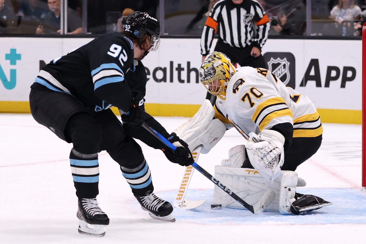 Oct 19, 2025; Salt Lake City, Utah, USA; Boston Bruins goaltender Joonas Korpisalo (70) makes a save against Utah Mammoth center Logan Cooley (92) during the first period at Delta Center. Mandatory Credit: Rob Gray-Imagn Images