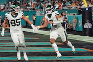 New York Jets' Mason Taylor (85) and Justin Fields (7) celebrate after Fields ran the ball...