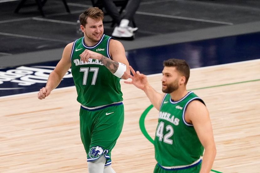 Dallas Mavericks' Luka Doncic (77) and Maxi Kleber (42) celebrate a 3-point basket scored by...