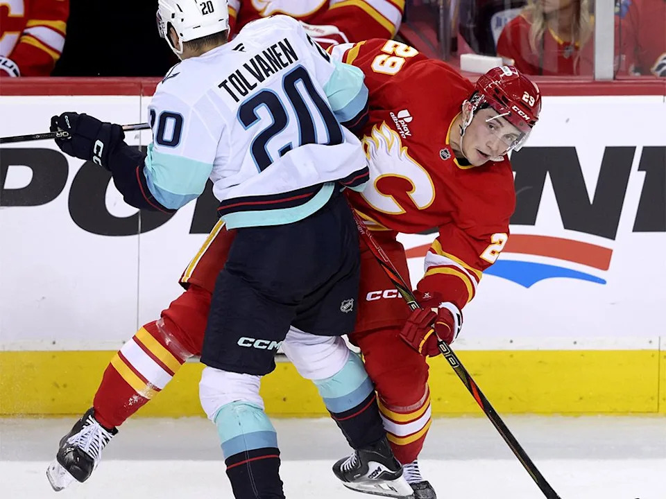 Calgary Flames forward Sam Honzek battles against Seattle Kraken forward Eeli Tolvanen in first-period pre-season NHL action at the Scotiabank Saddledome in Calgary on Tuesday, Sept. 23, 2025.