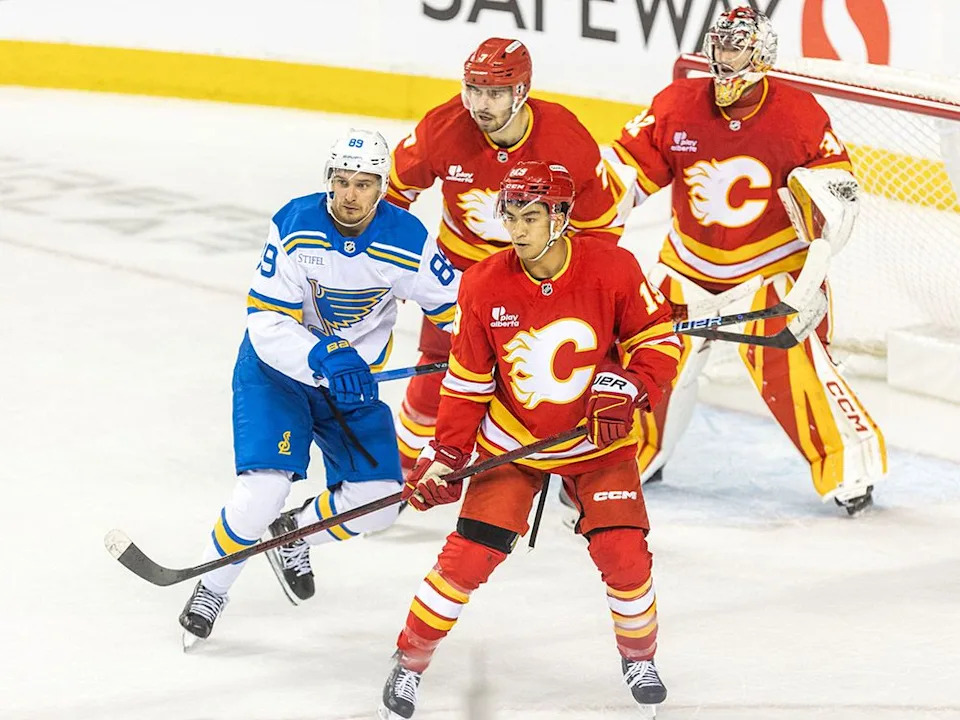 Calgary Flames defenceman Zayne Parekh, defenceman Kevin Bahl, and goaltender Dustin Wolf guard the crease during the third period of the home opener against the St. Louis Blues at the Scotiabank Saddledome on Saturday, Oct. 11, 2025.