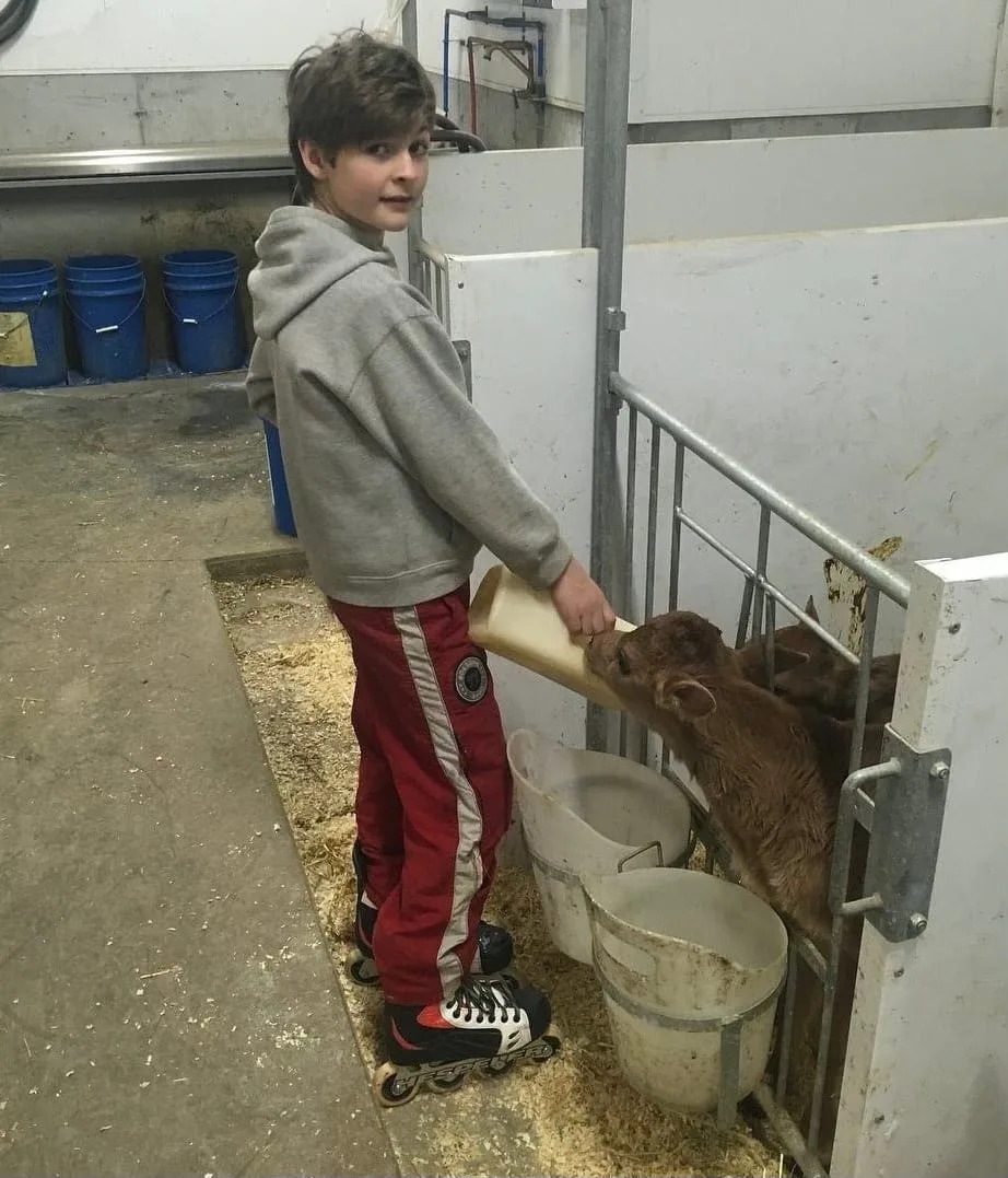 A young Brady Martin feeds cows on the Martin family farm while wearing roller blades