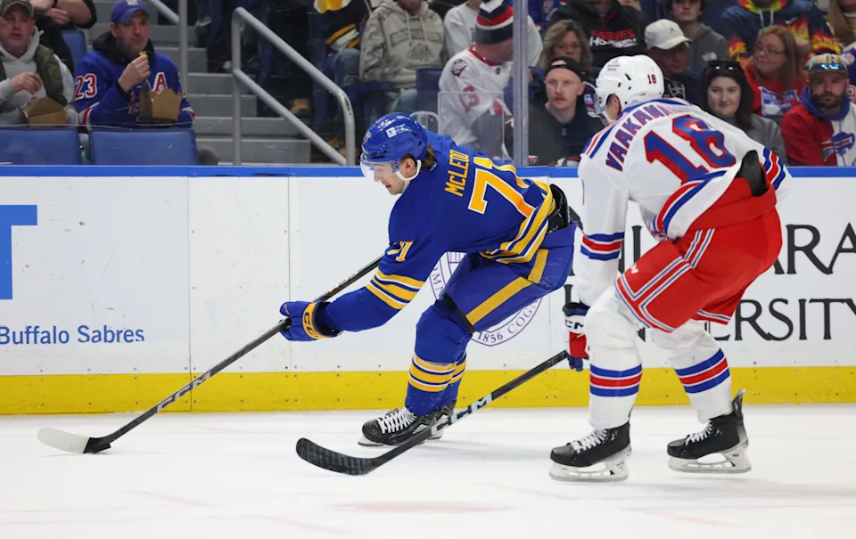 Feb 22, 2025; Buffalo, New York, USA; Buffalo Sabres center Ryan McLeod (71) controls the puck as New York Rangers defenseman Urho Vaakanainen (18) defends during the second period at KeyBank Center. Mandatory Credit: Timothy T. Ludwig-Imagn Images