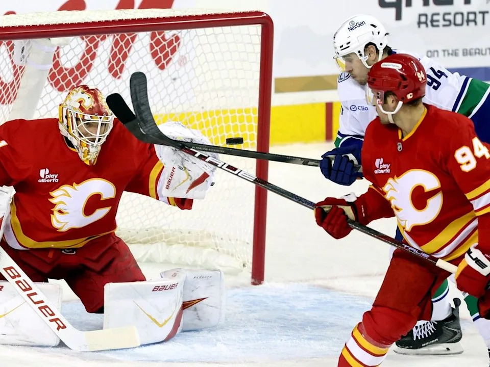  Flames goalie Devin Cooley denies Canucks winger Linus Karlson in pre-season matchup Oct. 1 in Calgary.