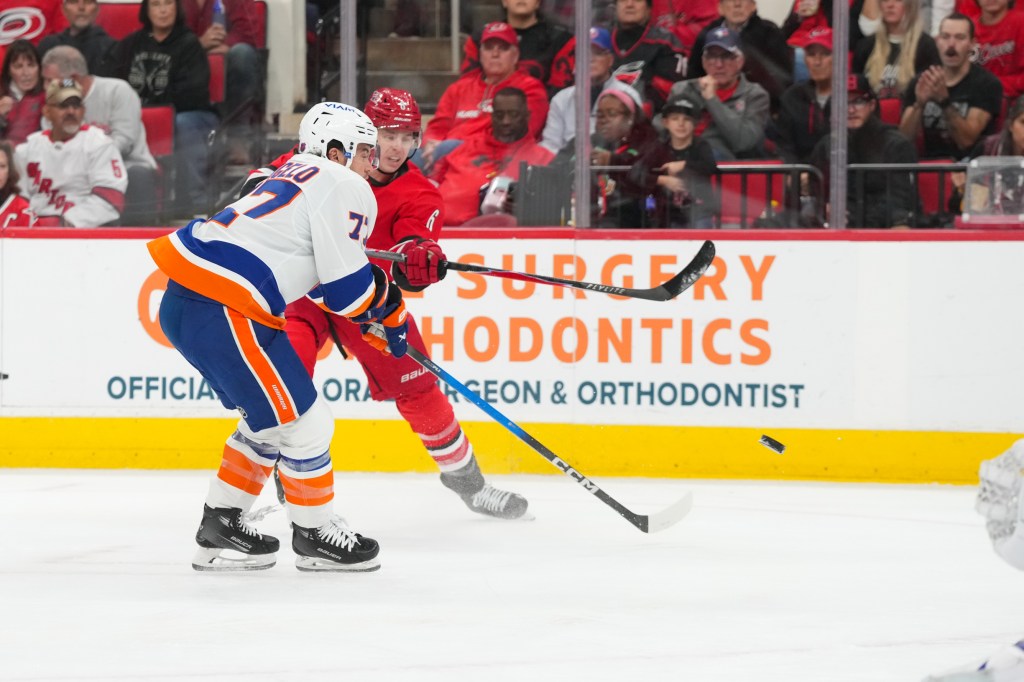 Mike Reilly (6) gets the shot away against New York Islanders defenseman Tony Deangelo (77) during the first period at Lenovo Center. 