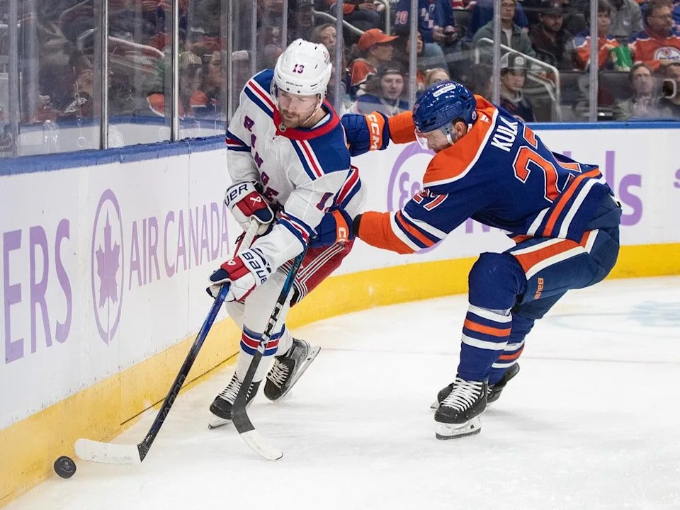  New York Rangers’ Alexis Lafreniere (13) and Edmonton Oilers’ Brett Kulak (27) battle for the puck during first period NHL action in Edmonton on Saturday, November 23, 2024.