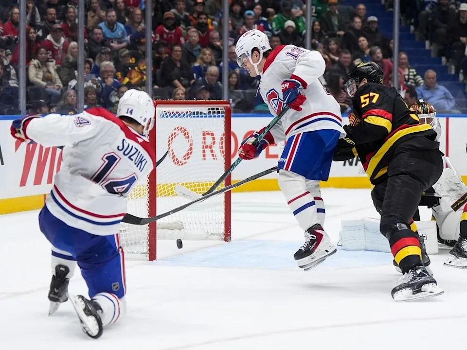  After a feed from Canadiens’ Ivan Demidov, not shown, Habs captain Nick Suzuki scores into an open net behind Canucks goalie Kevin Lankinen as Cole Caufield jumps in front of defenceman Tyler Myers during second period Saturday in Vancouver.