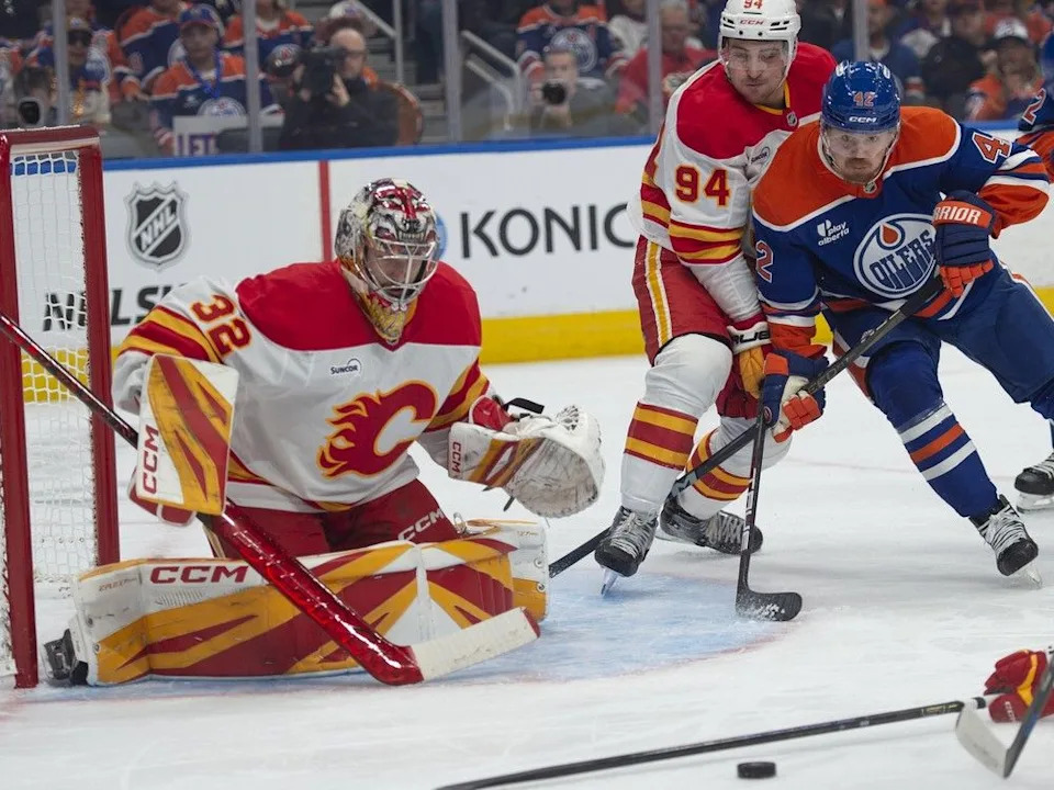  Oilers forward Kasperi Kapanen is hindered by Flames defenceman Brayden Pachal in front of goaltender Dustin Wolf on Wednesday.