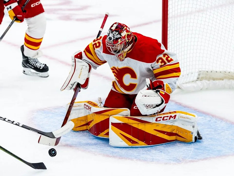  Calgary Flames goaltender Dustin Wolf makes a save during the first period of an NHL hockey game against the Seattle Kraken, Monday, Sept. 29, 2025, in Seattle.
