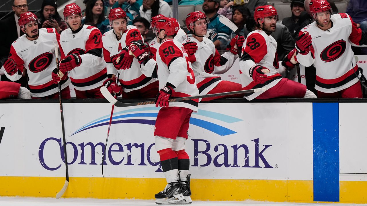 Carolina Hurricanes left wing Eric Robinson (50) celebrates with teammates after scoring a goal during the second period of an NHL hockey game against the San Jose Sharks, Tuesday, Oct. 14, 2025, in San Jose, Calif. (AP Photo/Godofredo A. Vásquez)