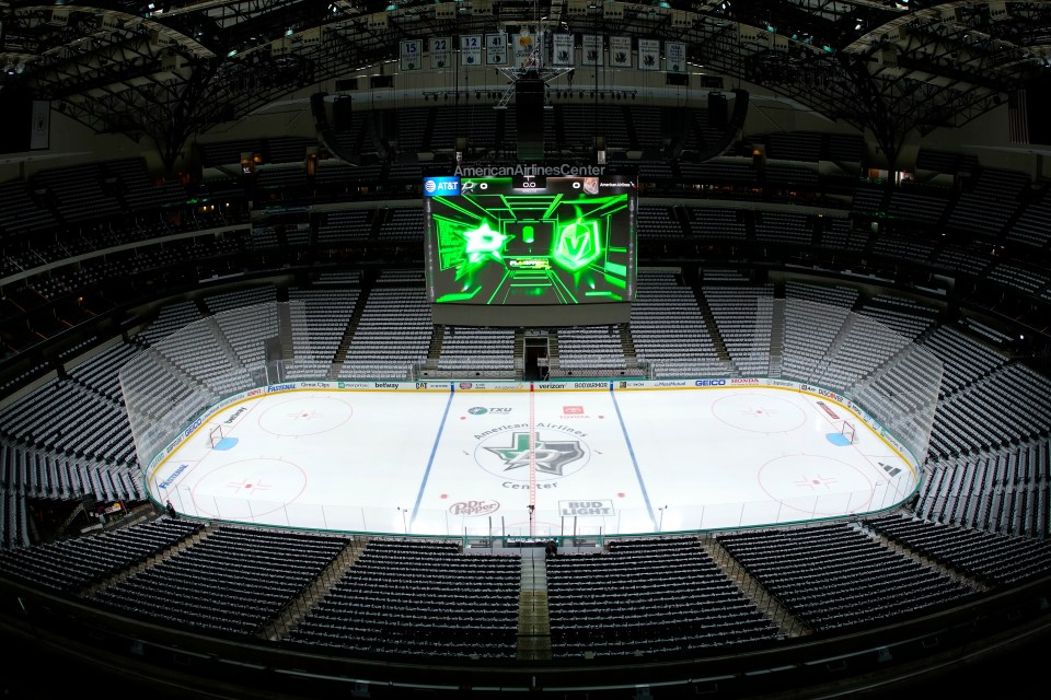 General view of American Airlines Center arena with empty seats and an ice hockey rink with a scoreboard displaying "Playoffs."